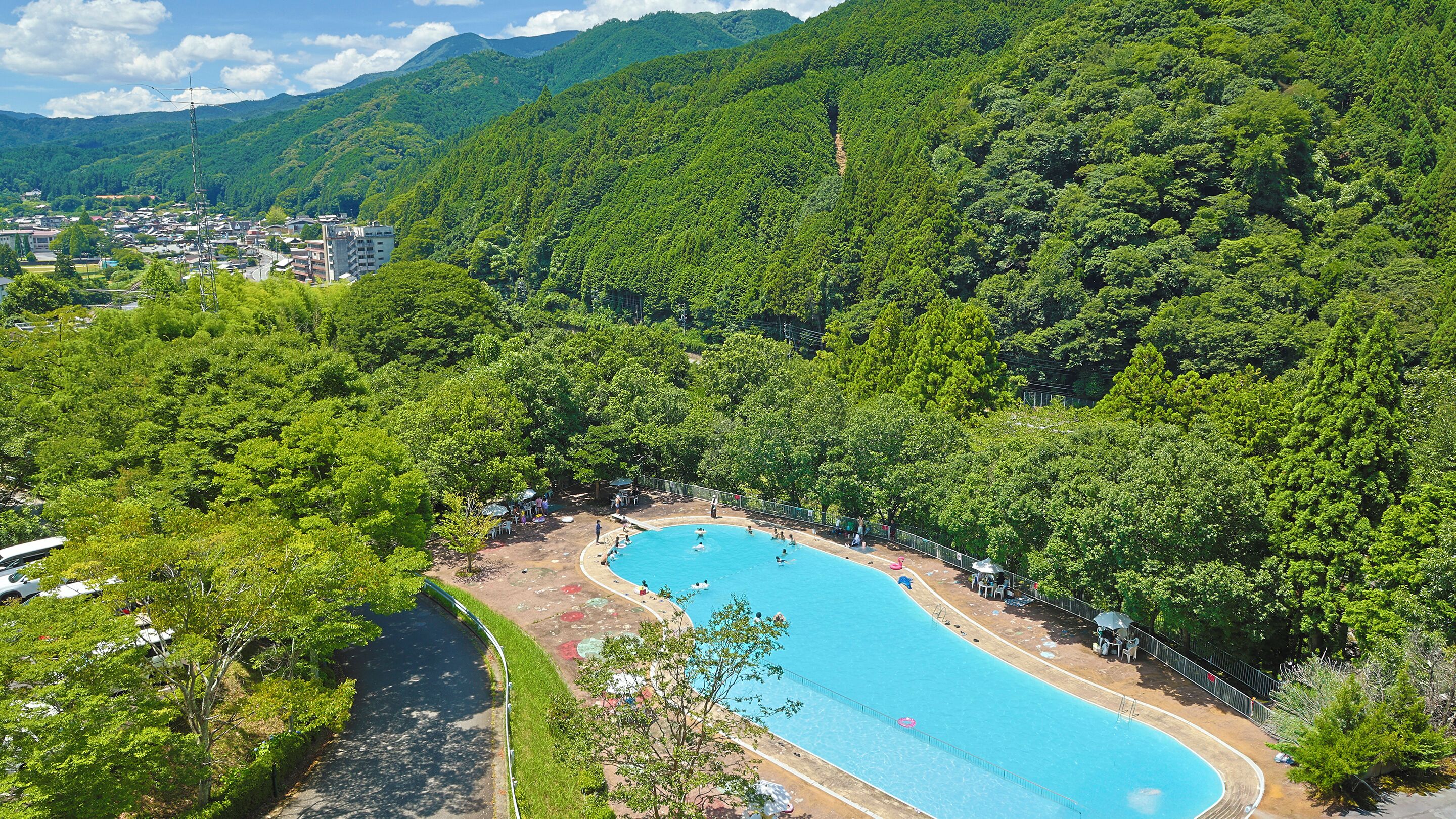 A swimming pool surrounded by lush greenery and hills.
