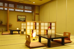 Traditional Japanese room with tatami flooring, low table, and sliding door.
