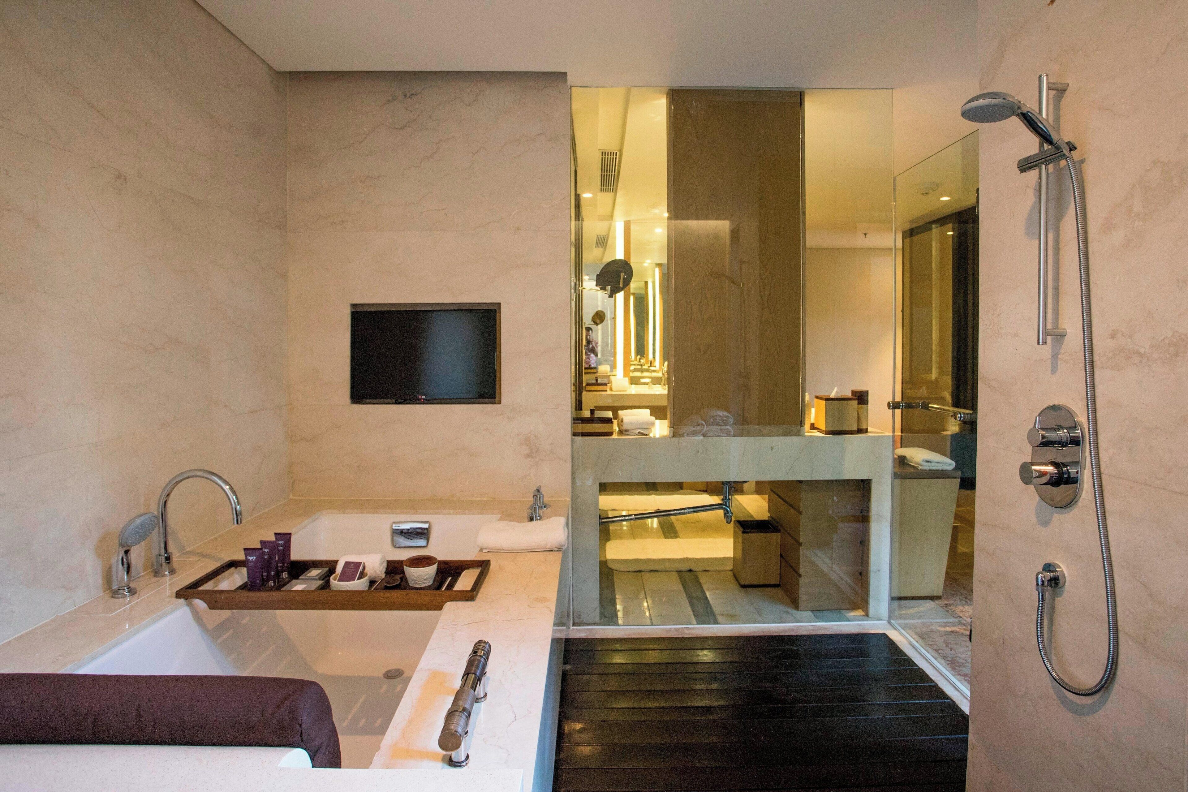 A modern bathroom with a bathtub, a glass-enclosed shower area, and a vanity with a mirror.