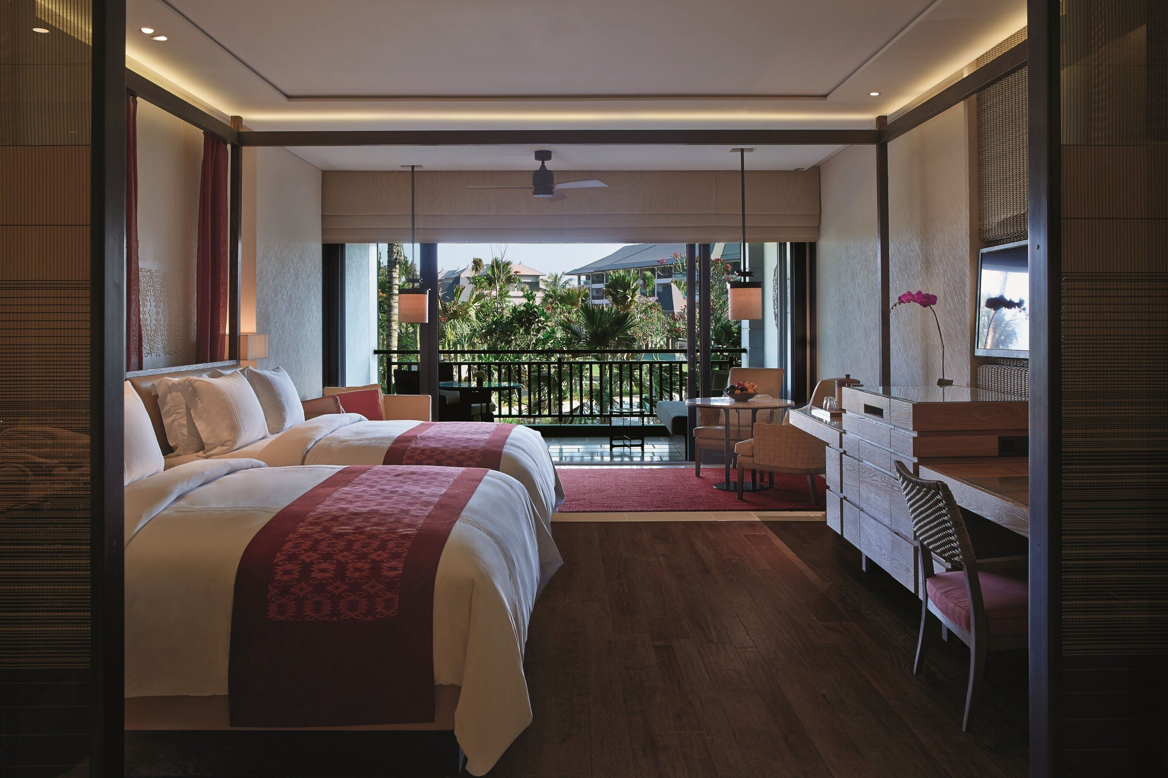 Une chambre d’hôtel moderne avec deux lits, un balcon, un bureau et une salle de bain.