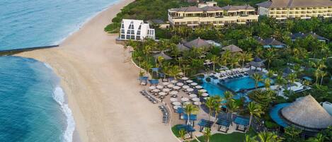 A resort with a beach, a swimming pool, and multiple villas.