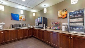 Cocina de hotel con microondas, cafetera y refrigerador que dice 'Chill Out'.