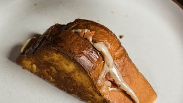 A person holding a grilled sandwich with visible fillings.
