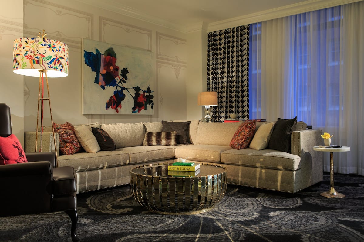 A modern living room with a sectional sofa, a round coffee table, and a floor lamp.