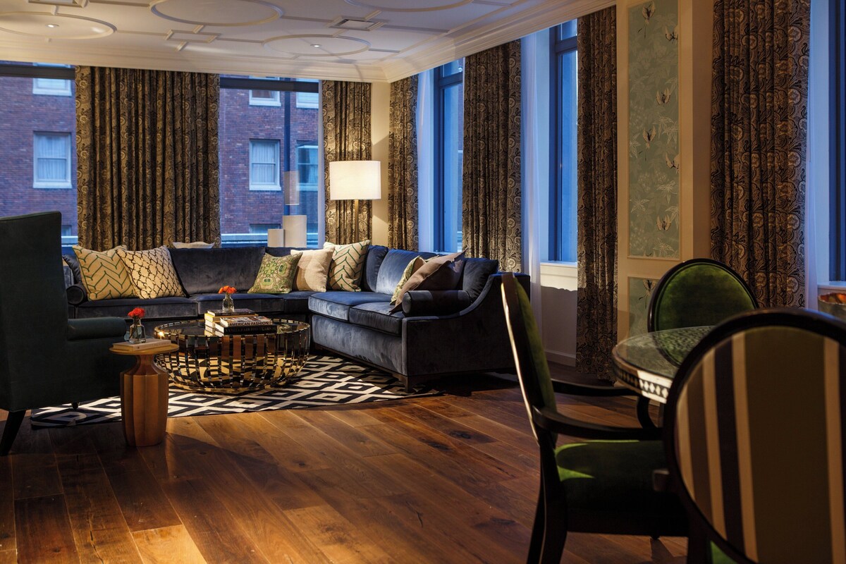 A modern living room with a sectional sofa, a round coffee table, and a green armchair.