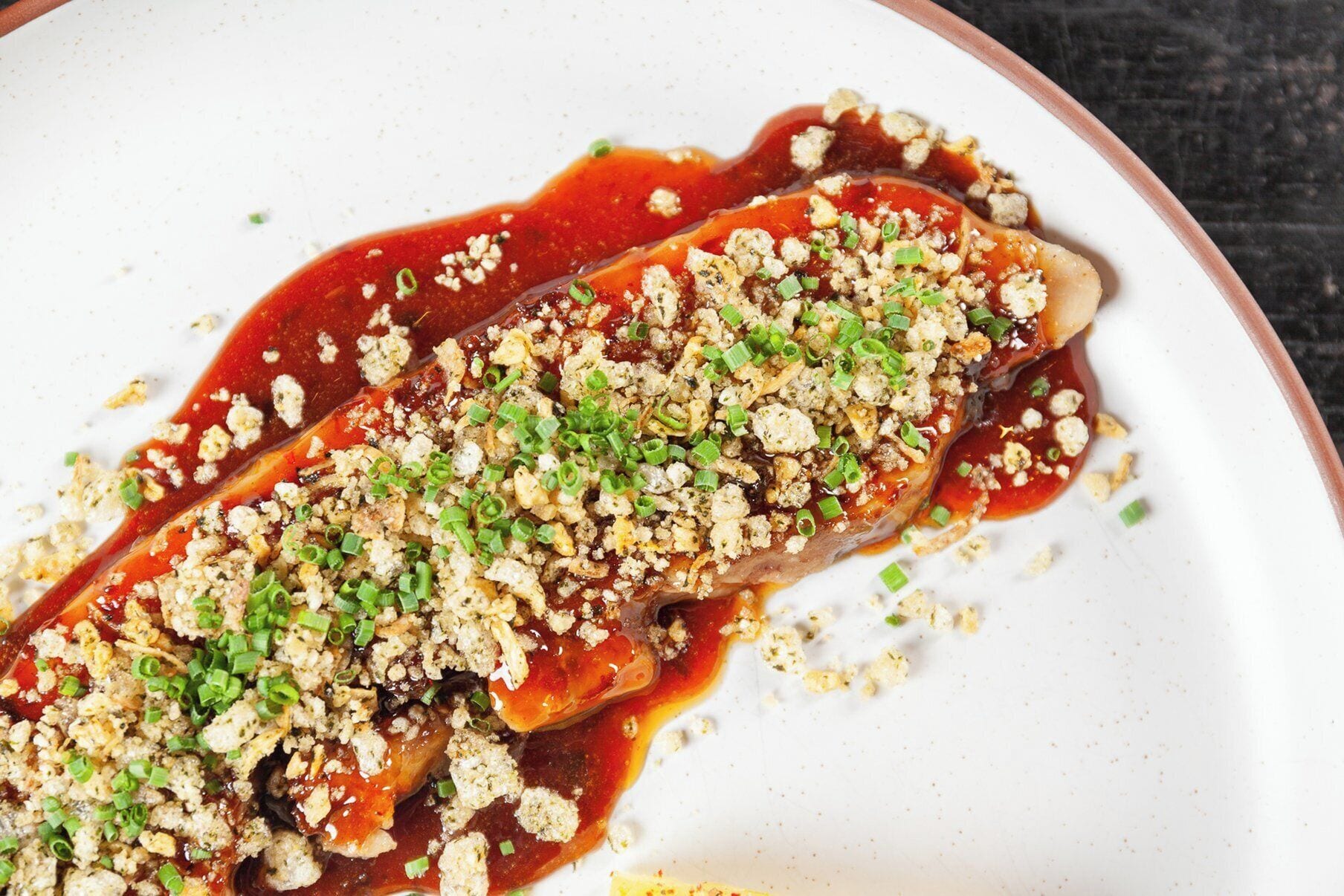 Un plato con salsa y cobertura desmenuzada.