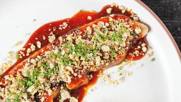 Un plato con salsa y cobertura desmenuzada.