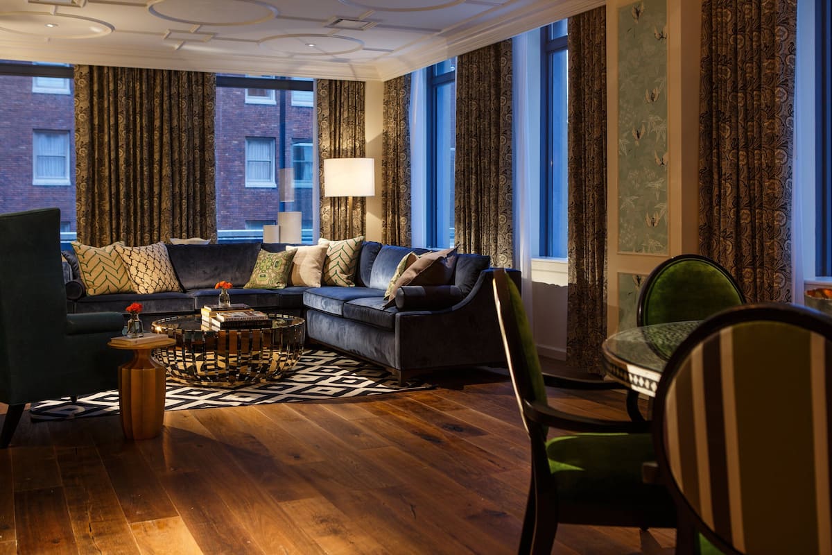 A modern living room with a sectional sofa, a round coffee table, and a green armchair.