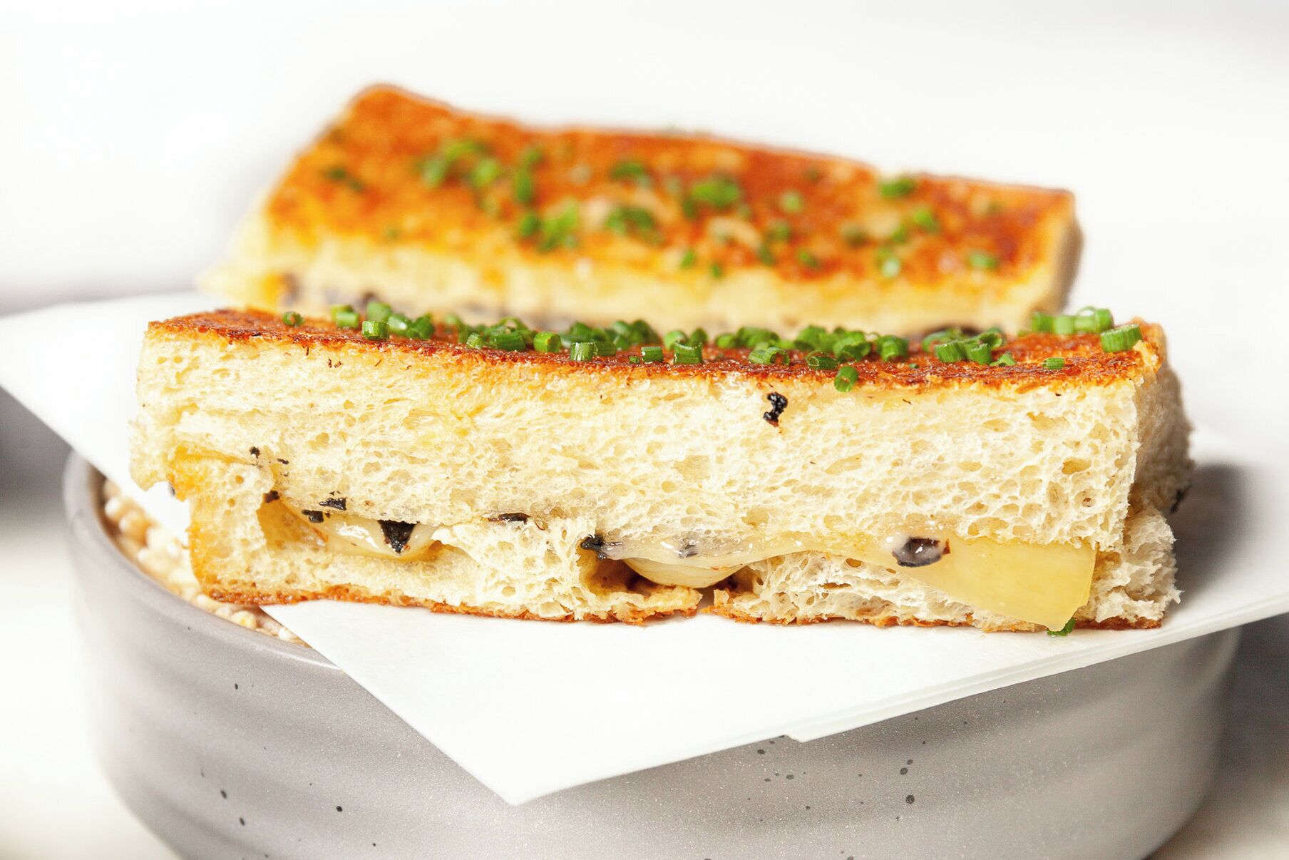 Un panino tagliato a metà su un piatto bianco.