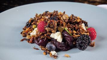 Um prato de granola com frutas vermelhas e nozes.