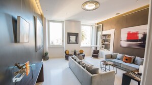 Un salon moderne avec un canapé gris, une table basse et une bibliothèque.