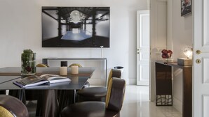 Un espace de salle à manger moderne, doté d’une grande table, de chaises et d’une œuvre d’art accrochée au mur.