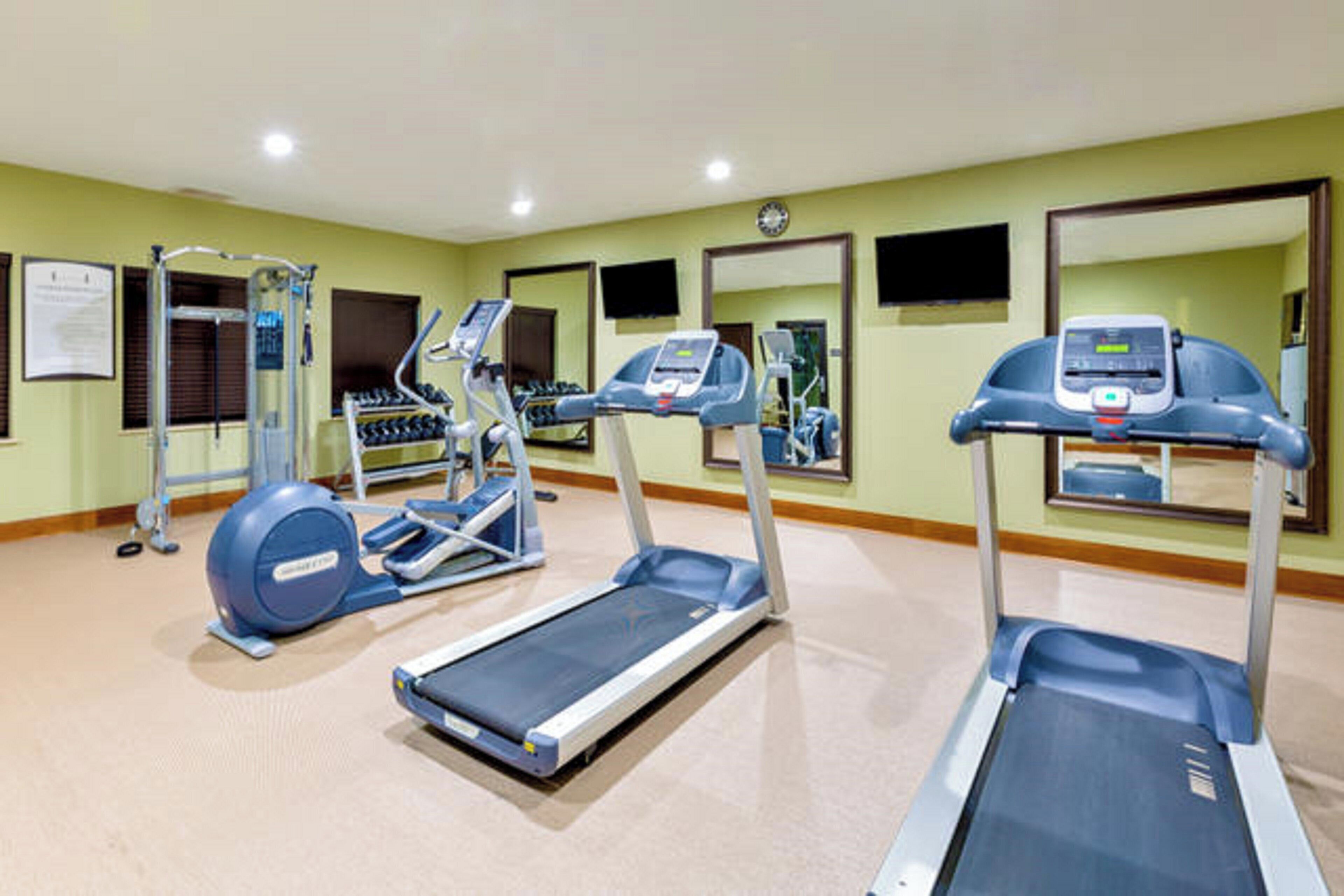 A fitness center with treadmills, elliptical machines, and a stationary bike.