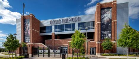 A modern building with the sign "DAVIS DIAMOND" and "Welcome to Aggie Land" on the facade.