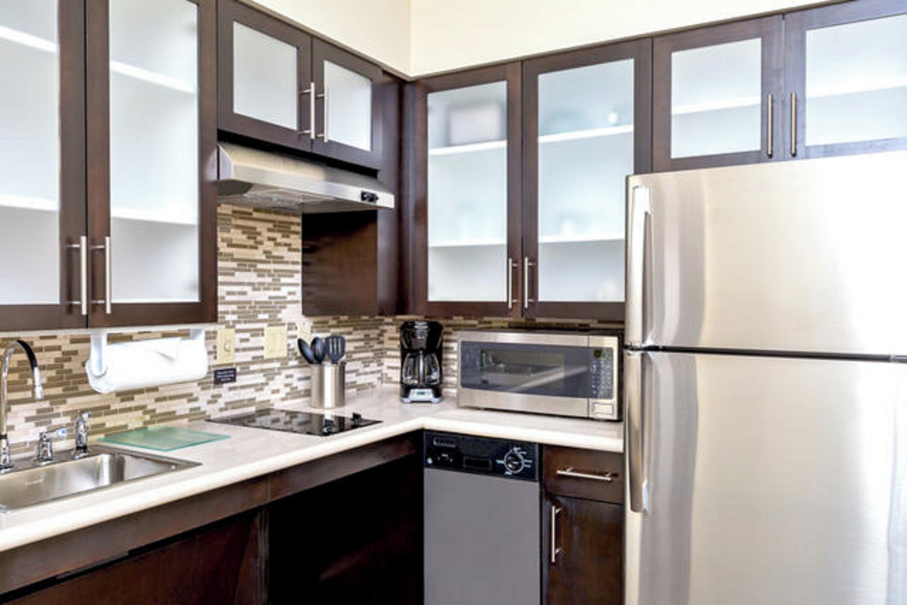 A modern kitchen with stainless steel appliances, a dishwasher, and a coffee maker.
