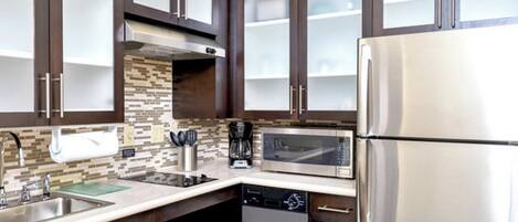 A modern kitchen with stainless steel appliances, a dishwasher, and a coffee maker.