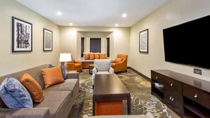 A hotel room with a sofa set, a coffee table, a TV, and framed artwork on the walls. - Staybridge Suites College Station by IHG (College Station)