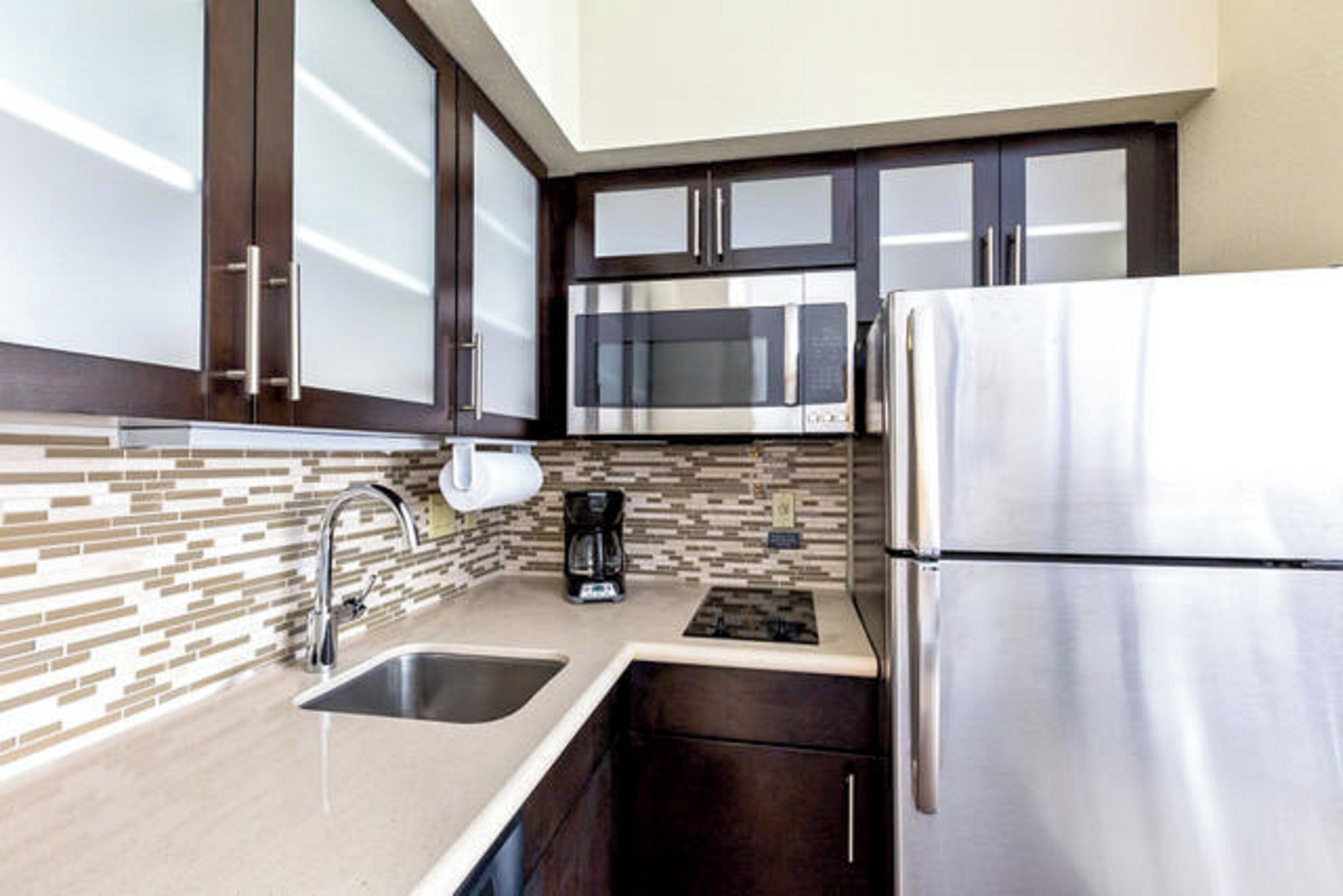 A modern kitchen with stainless steel appliances, a double sink, and a coffee maker.