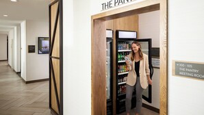 A hallway with a sign for 'The Pantry' and a vending machine. - Staybridge Suites College Station by IHG (College Station)