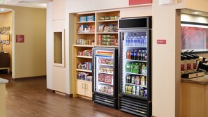 Zona de máquinas expendedoras con opciones de refrigerios refrigerados y no refrigerados, como cereales y bebidas.