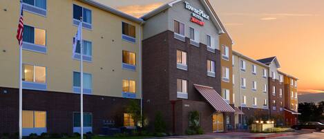 A TownePlace Suites hotel with a brick facade, multiple windows, and a parking lot.
