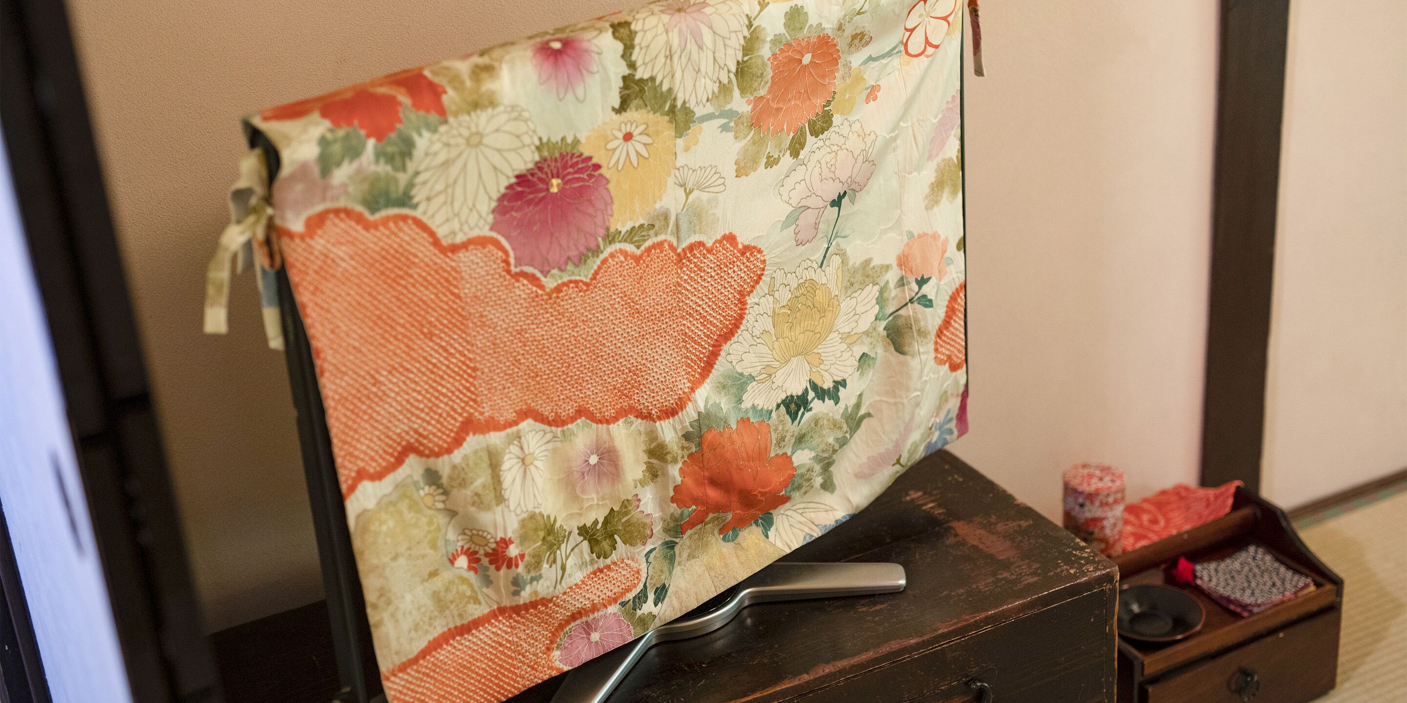 A bed with a floral bedspread and a wooden headboard.