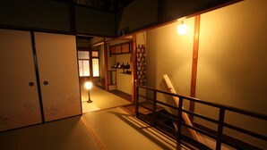 Una habitación japonesa tradicional con suelo de tatami, puertas correderas y una escalera de madera.