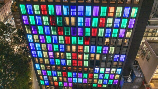 A high-rise building with a grid of windows, some with colorful lighting. - Hyatt Centric Milan Centrale (Milan)