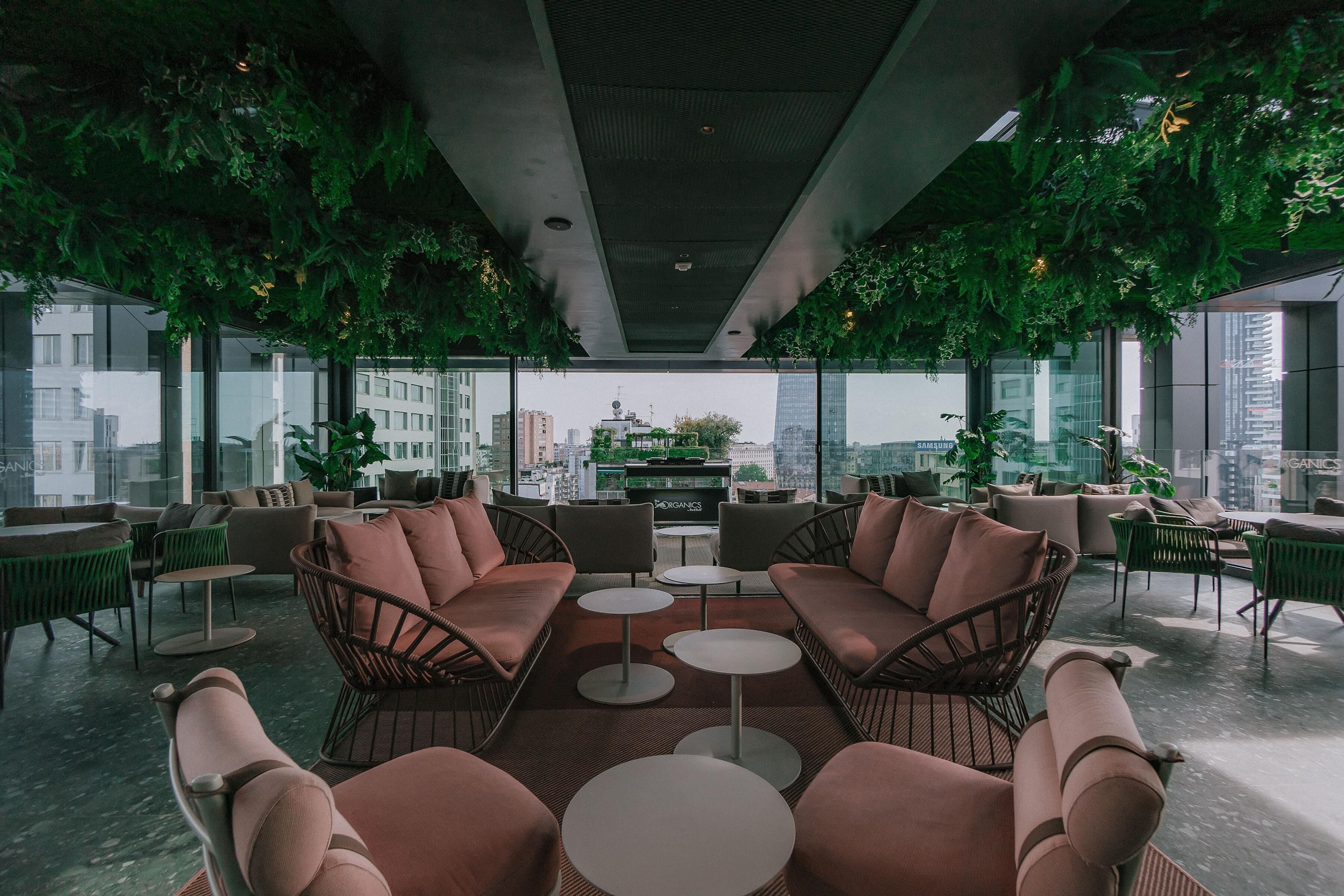 A modern lounge area with seating, tables, and a city view.