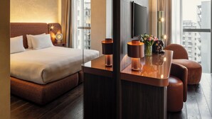 A hotel room with a bed, a desk, a chair, a TV, and a window with curtains. - Hyatt Centric Milan Centrale (Milan)