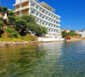 A multi-story hotel with balconies, located beside a body of water. - Porto Evia Boutique Hotel by Xenia Resorts (Eretria)
