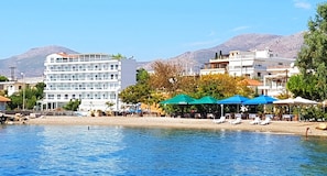 A coastal hotel with multiple floors, a beachside location, and outdoor seating areas. - Porto Evia Boutique Hotel by Xenia Resorts (Eretria)