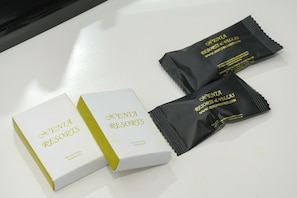 Kaksi valkoista laatikkoa ja kaksi mustaa pakettia, joissa on merkintä ”Xenia Resorts”, asetettu valkoiselle alustalle.