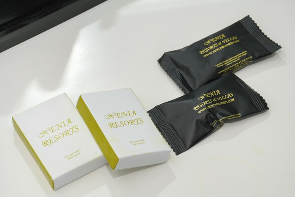 Two white boxes and two black packets with 'Xenia Resorts' branding, placed on a white surface.