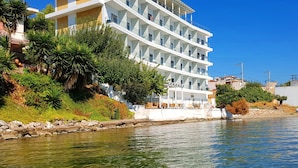 Un hotel de varios pisos con balcones, situado junto al agua.