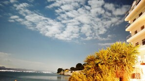 A coastal view with a clear sky, a calm sea, and a building with balconies. - Porto Evia Boutique Hotel by Xenia Resorts (Eretria)