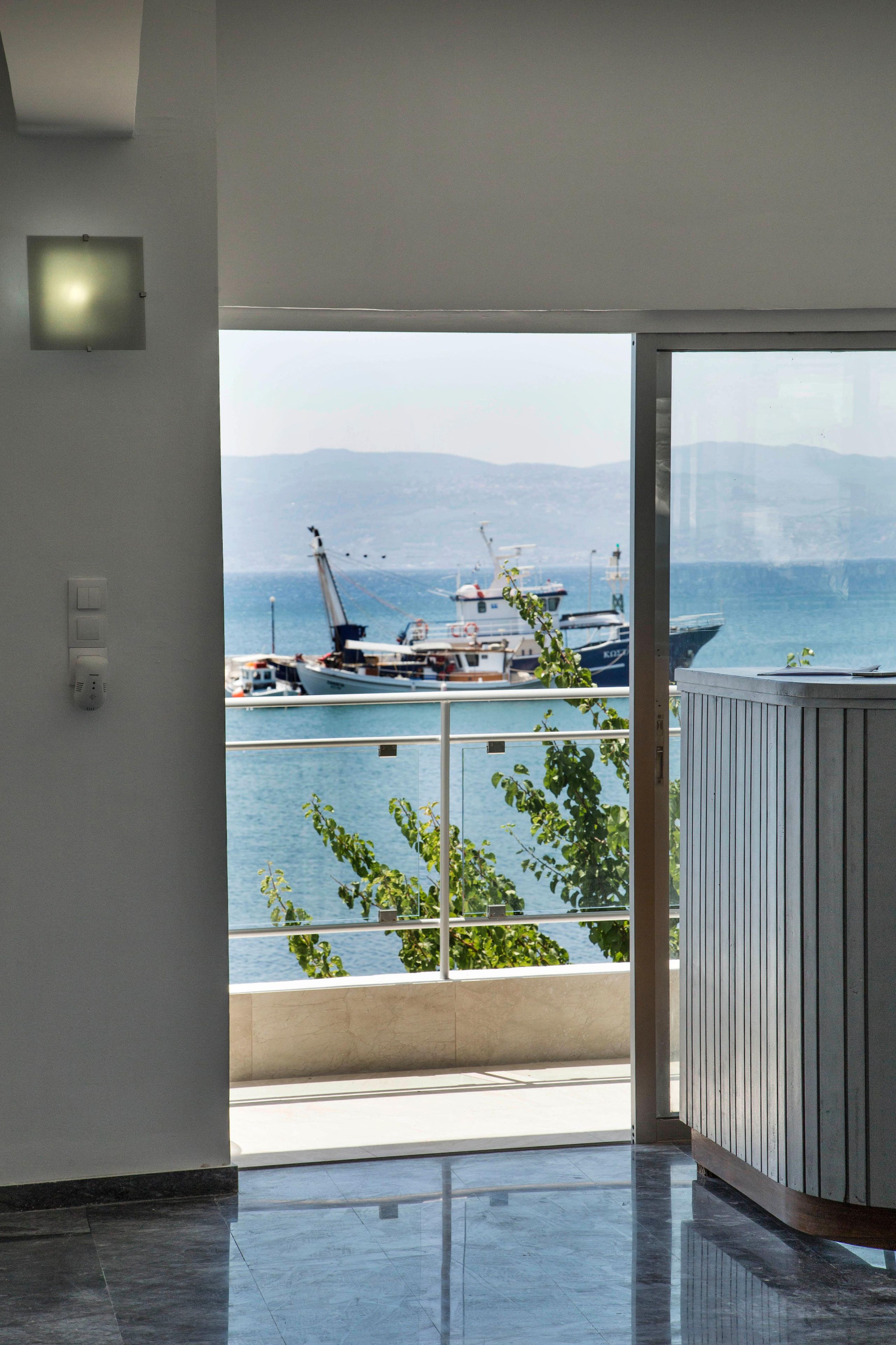 Un interior moderno con un amplio ventanal con vistas a un puerto deportivo.