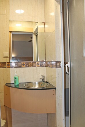 A bathroom with a sink, mirror, and shower door. - Residencial Paranhos (Porto)