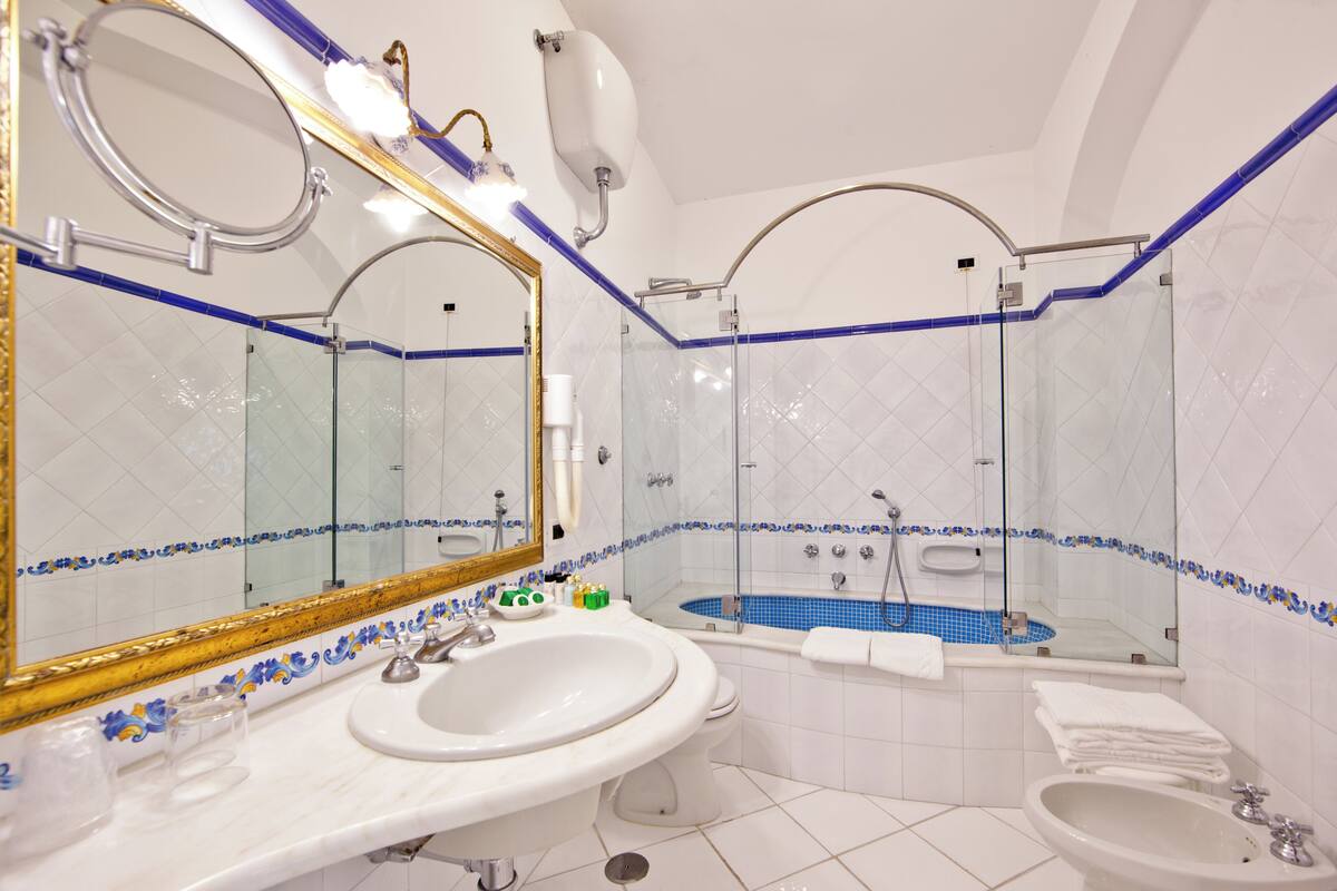 classic room with patio and garden view | bathroom | free toiletries, hair dryer, slippers, towels