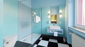 Ein modernes Badezimmer mit Duschkabine aus Glas, einem schwarz-weißen Schachbrettboden, einem weißen Waschbecken und einem großen Spiegel mit Wandleuchten.