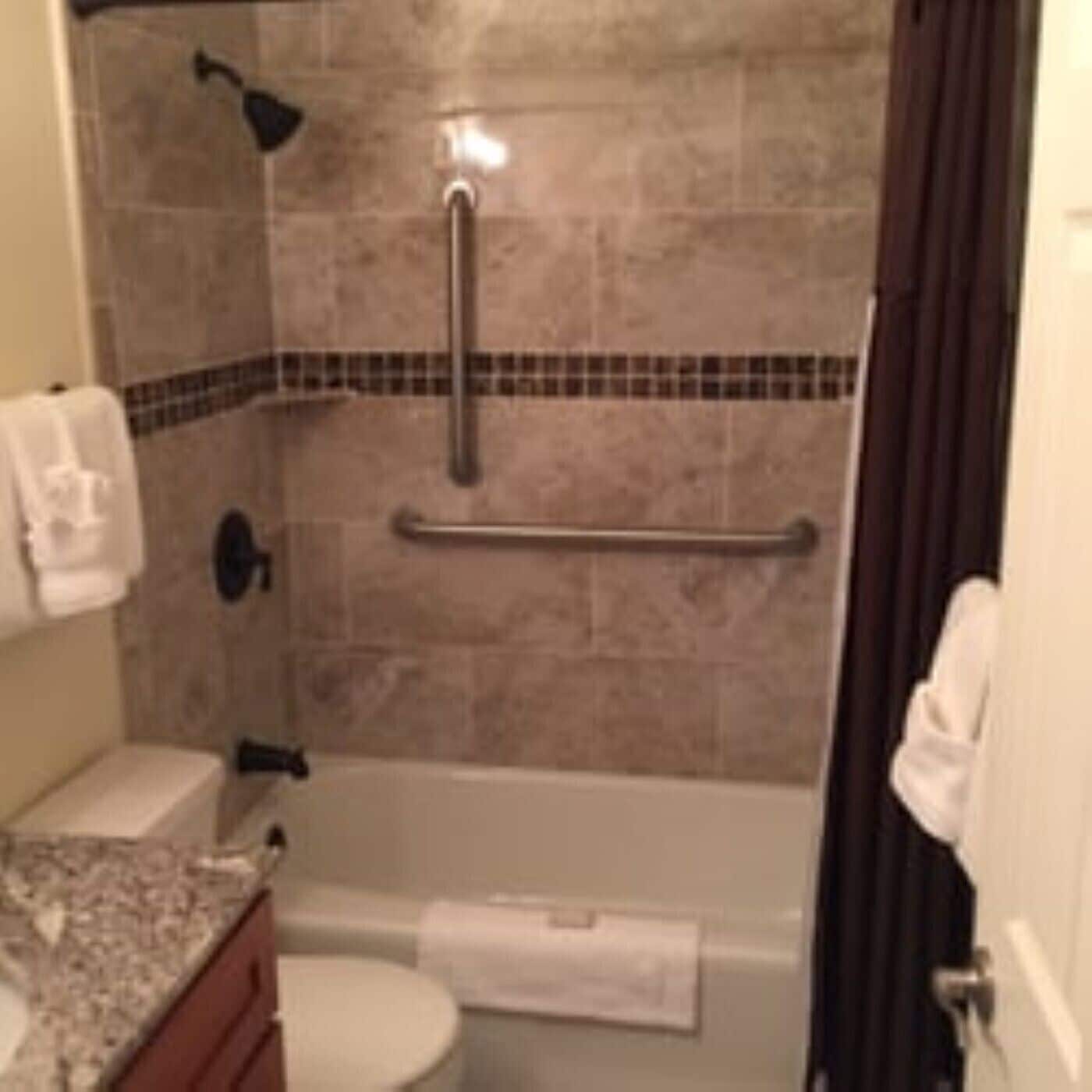 A bathroom with a shower, toilet, and sink.