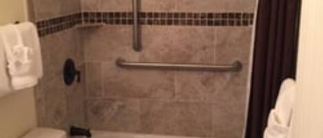 A bathroom with a shower, toilet, and sink.