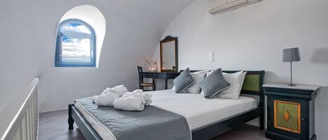A bedroom with a bed, a dresser, a mirror, and a window.