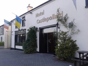 A building labeled "Hotel Castlepollard" with a flag and a sign for "Rosewood." - Hotel Castlepollard (Castlepollard)