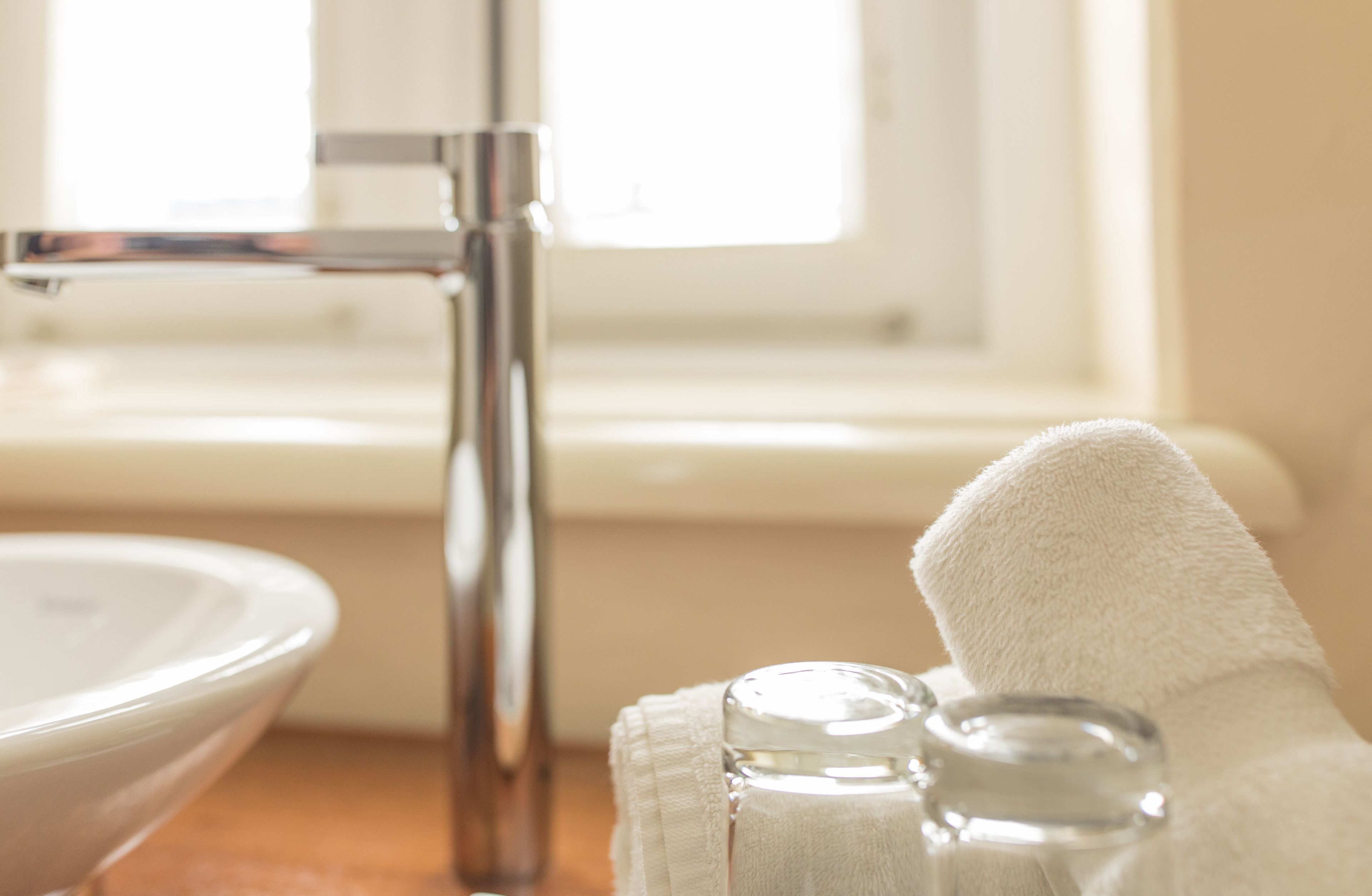 A bathroom sink, a towel, and a glass bottle.