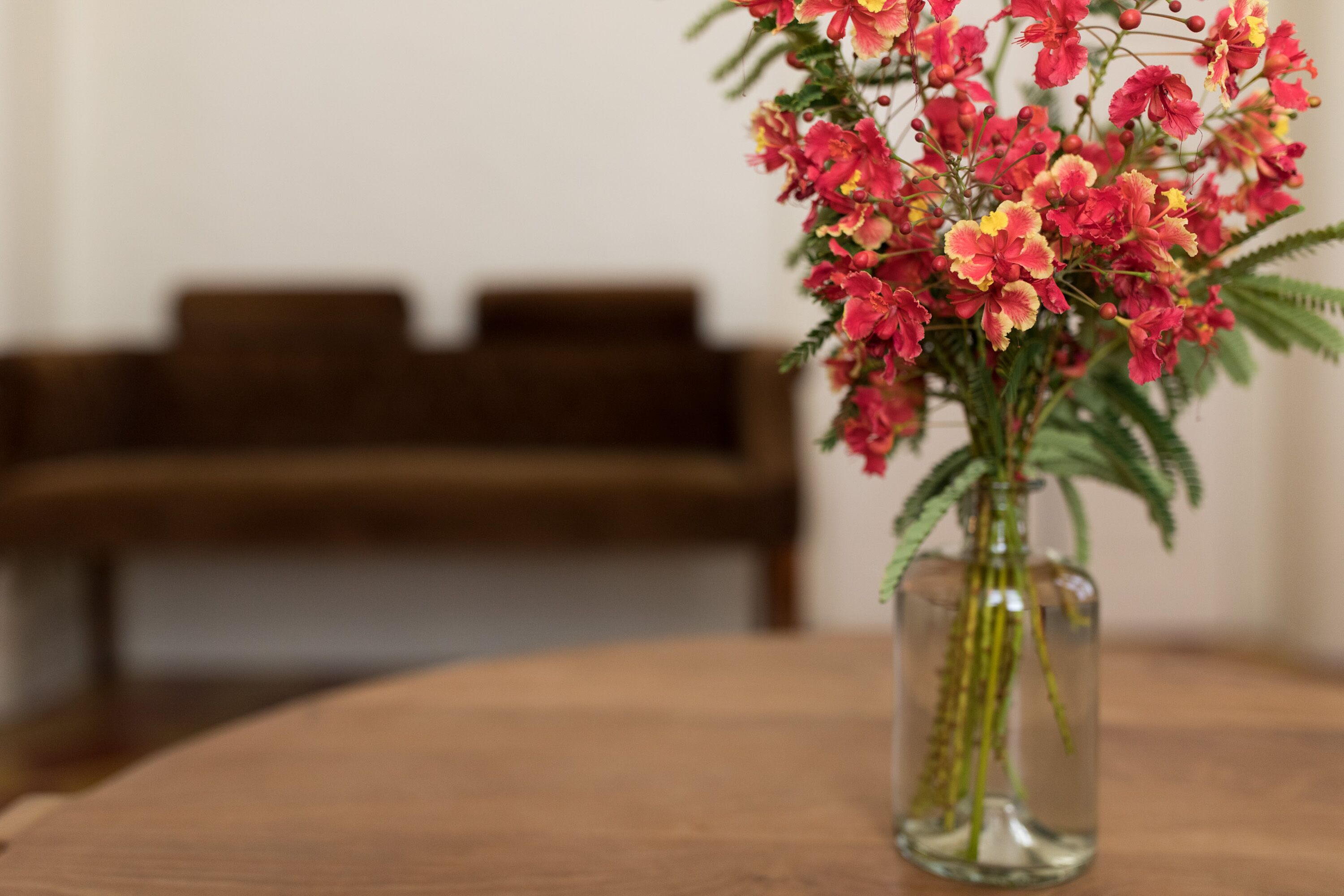 A vase with flowers on a wooden table.