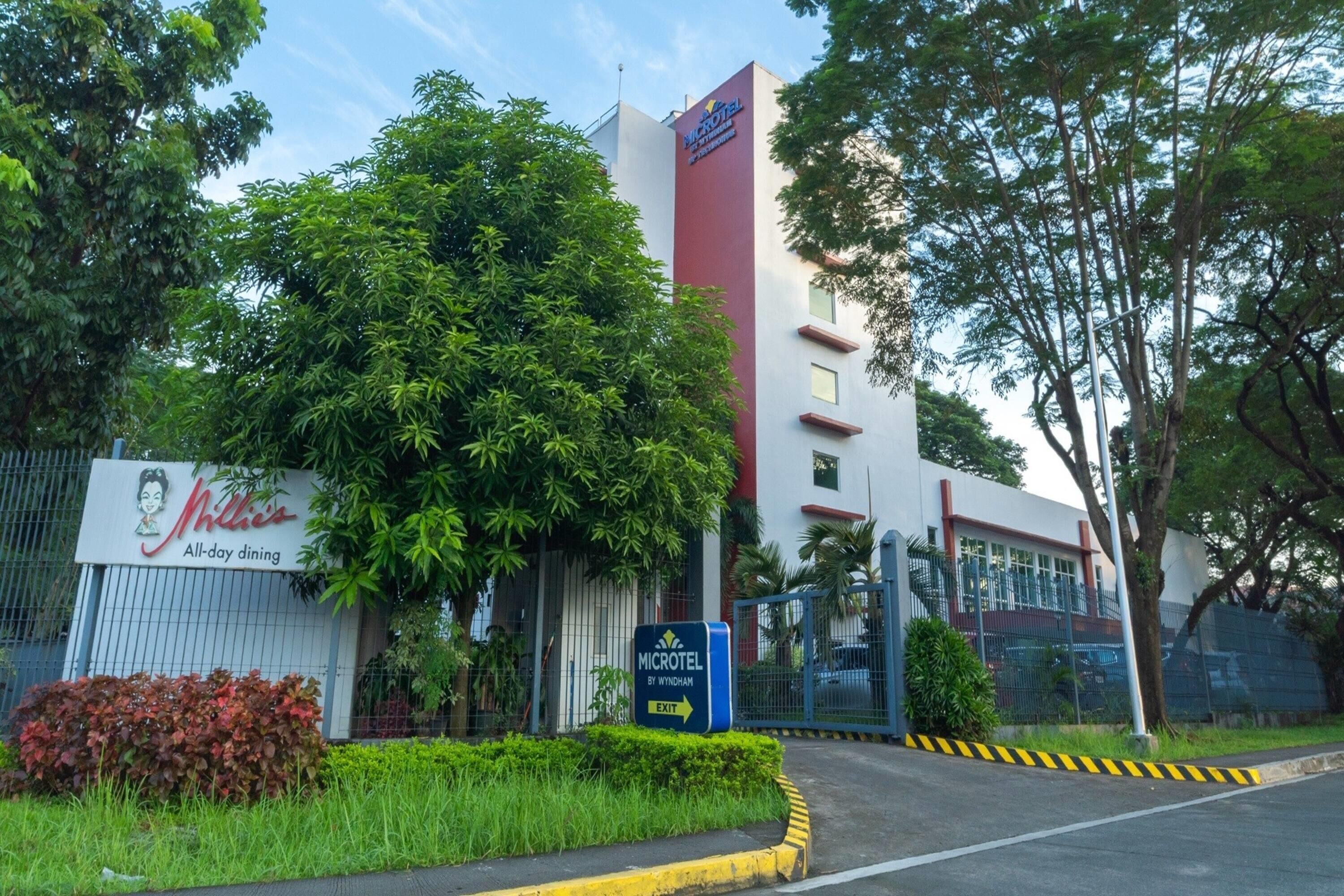 Entrada de un hotel con un letrero que dice 'MICROTEL BY WINHAM' y un letrero de 'SALIDA'.