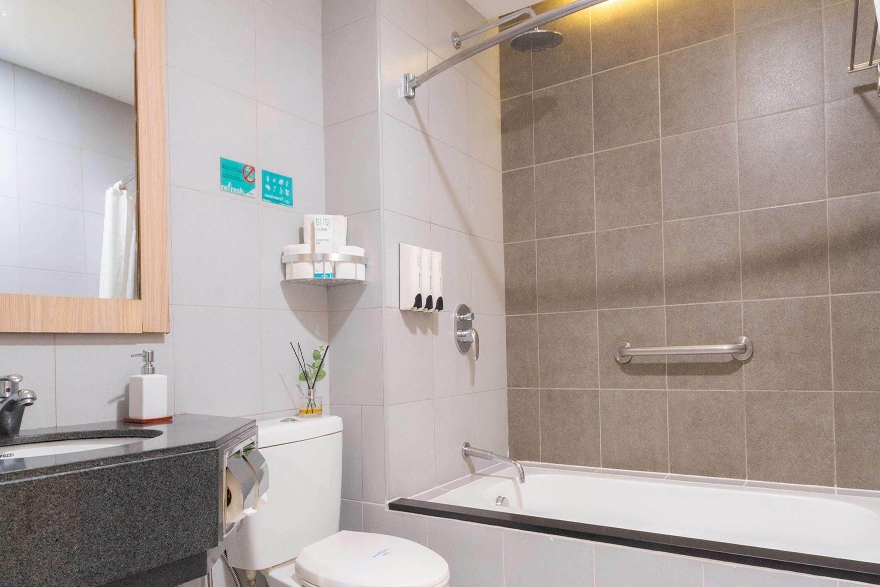 A modern bathroom with a toilet, sink, and bathtub.
