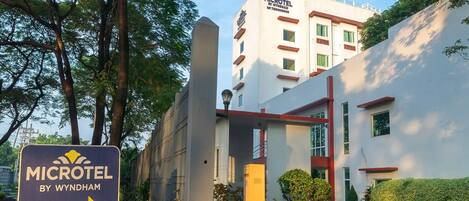 A hotel entrance with a sign indicating 'MICROTEL BY WYNDHAM' and an arrow pointing towards the building.