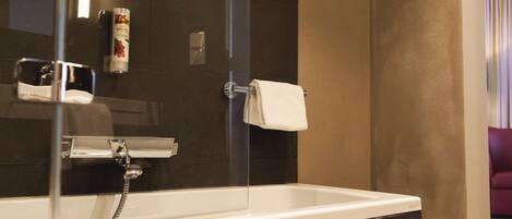 Une salle de bain équipée d’une baignoire, d’un porte-serviettes et d’un sèche-mains.